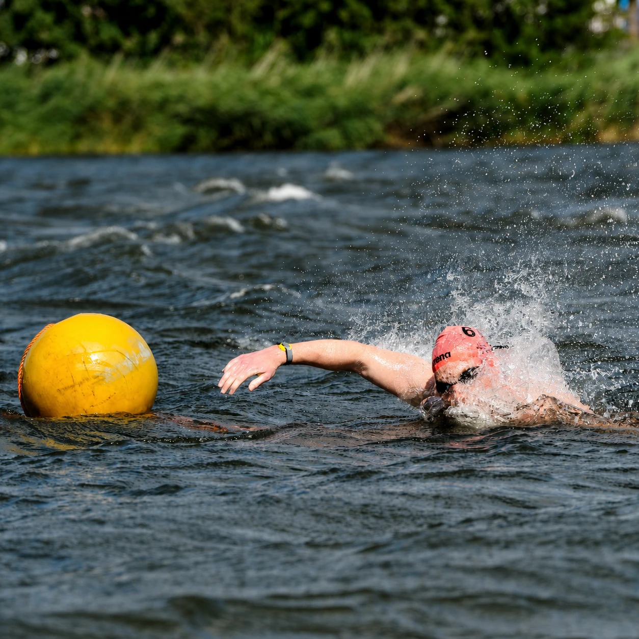 Timo Dinkelberg zwemt in open water langs een gele boei.